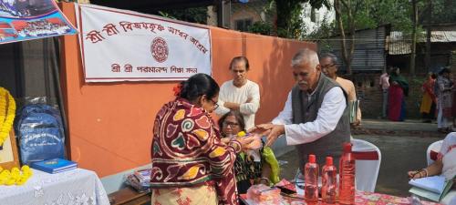 শ্রী শ্রী বিজয়কৃষ্ণ সাধন আশ্রম , শ্যামনগর এর  শ্রী শ্রী পরমানন্দ শিক্ষা সদন স্কুল পড়ুয়াদের মধ্যে স্কুল ব্যাগ বিতরন করা হচ্ছে।